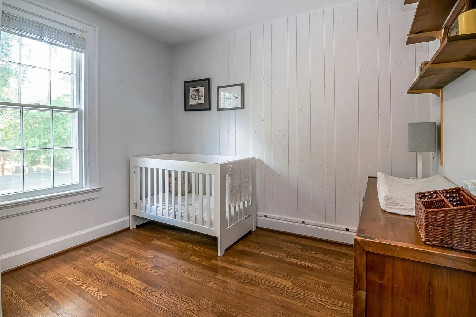 A bright nursery with a crib in window light