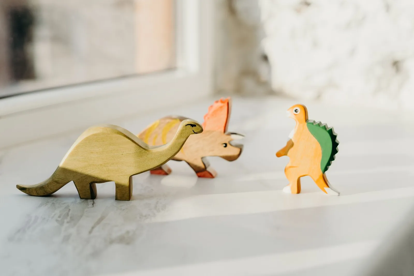 Well-loved wooden toys on a windowsill in soft light